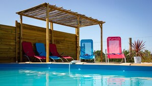 A pool area with wooden deck, lounge chairs, and a pergola. - Peaceful Countryside Gite with private pool near Aubeterre (Laprade)