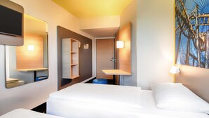 A hotel room with two beds, a bathroom with a sink and mirror, and a painting on the wall. - B&B Hotel Rust-Ettenheim (Mahlberg)