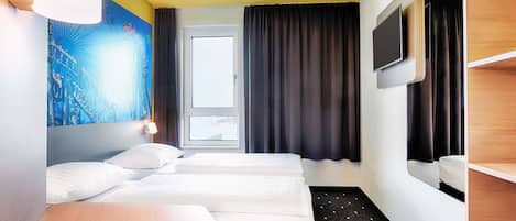 Habitación de hotel con dos camas, un escritorio, una silla, un televisor y un cuadro en la pared.
