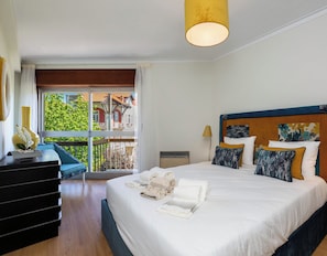 A modern hotel room with a large bed, a balcony, and a view of the city.
