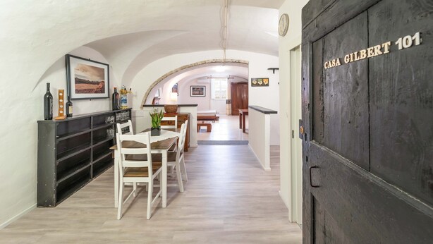 A hallway with a dining area, a kitchen, and a door labeled 'Casa Gilbert 101'. - Loft Apartment ‘Casa Gilbert 101’ close to Beach with Wi-Fi (alghero)