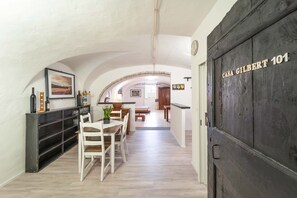 A hallway with a dining area, a kitchen, and a door labeled 'Casa Gilbert 101'.
