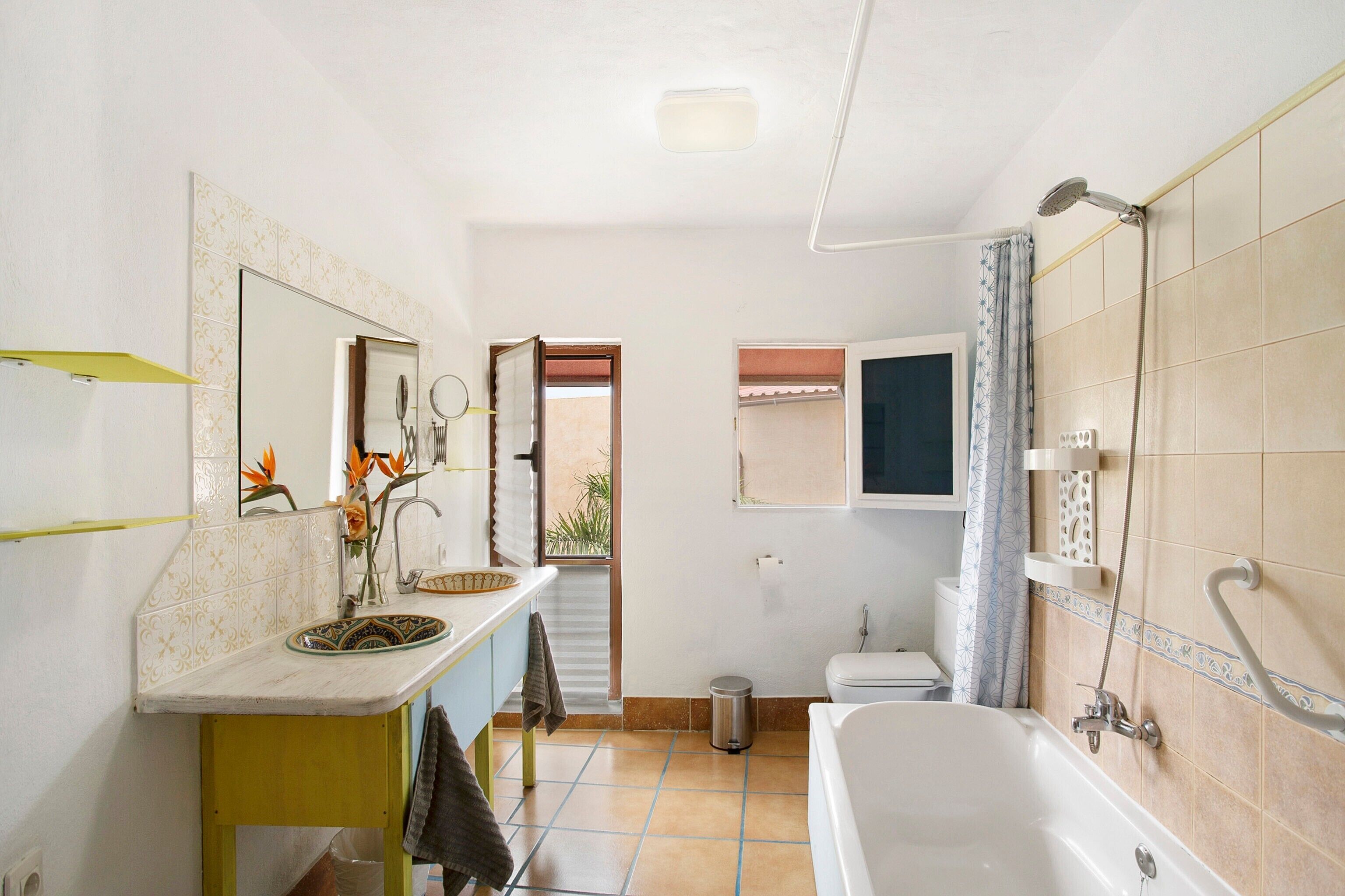 Een badkamer met een wastafel, spiegel, douche en toilet.