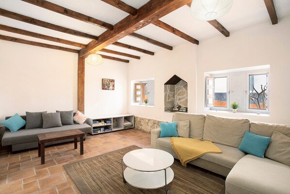 A living room with two sofas, a coffee table, and a stone fireplace.