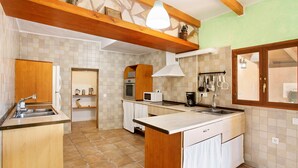 Una cocina con armarios de madera, una isla central, un microondas y un fregadero.
