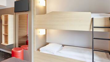 Une chambre avec un lit superposé, une télévision, une étagère et un tabouret rouge.