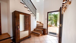 A staircase leading to a second floor, a wooden door, and a view of the outdoors. - Beautiful Holiday Home “Son Llodra” with Mountain View, Pool, Terrace & WiFi (Son Macia)