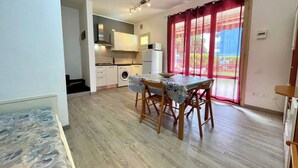 Espai vital compacte amb zona de menjador, cuina i vistes a través d'una finestra gran.
