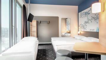 Ein modernes Hotelzimmer mit zwei Einzelbetten, einem kleinen Tisch und einem großen Fenster.