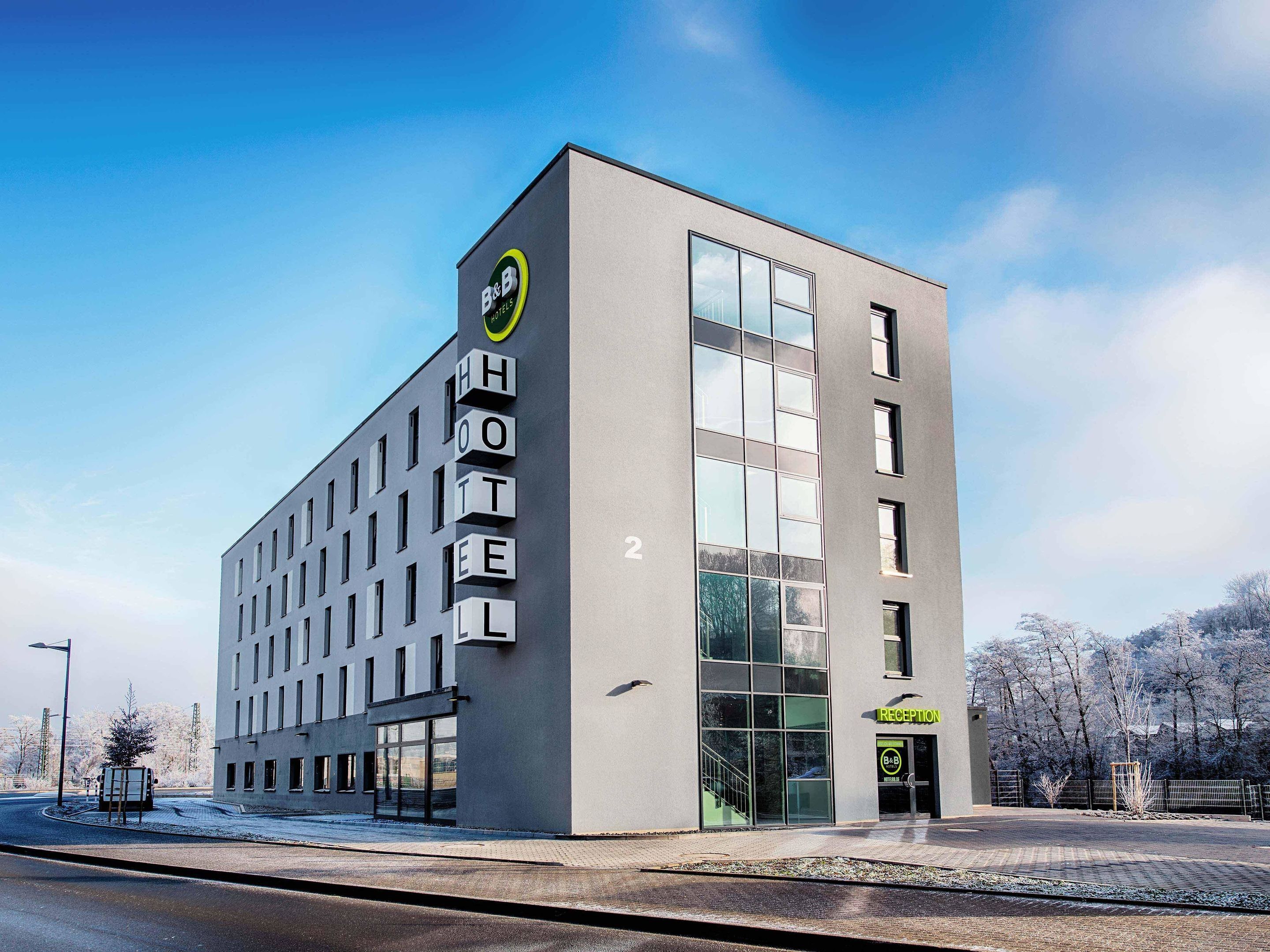 A modern hotel building with a clear reception area and a large glass facade.
