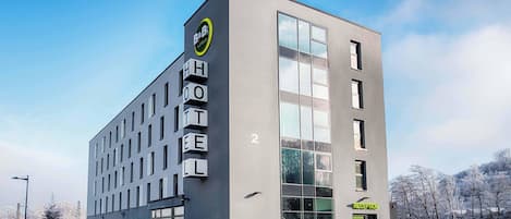 A modern hotel building with a clear reception area and a large glass facade.