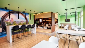 A modern conference room with a wooden floor, white tables, and black chairs.