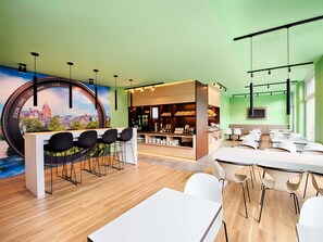 A modern conference room with a wooden floor, white tables, and black chairs. - B&B Hotel Wetzlar (Wetzlar)