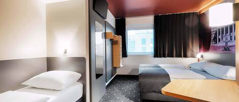 Une chambre d’hôtel moderne avec deux lits, une petite table et un banc.