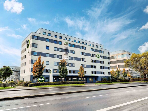 Un hôtel à plusieurs étages au design moderne, dont la façade est ornée d’un logo bien visible de la chaîne B&B.