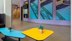 A modern lobby with a curved wall, a reception desk, and a seating area with two tables.