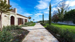 A stone pathway leading to a stone building with arched doors and shutters. - Borgo Da Monte 8, Emma Villas (Monteprandone)