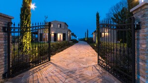 A stone pathway leading to a house with a metal gate. - Borgo Da Monte 8, Emma Villas (Monteprandone)