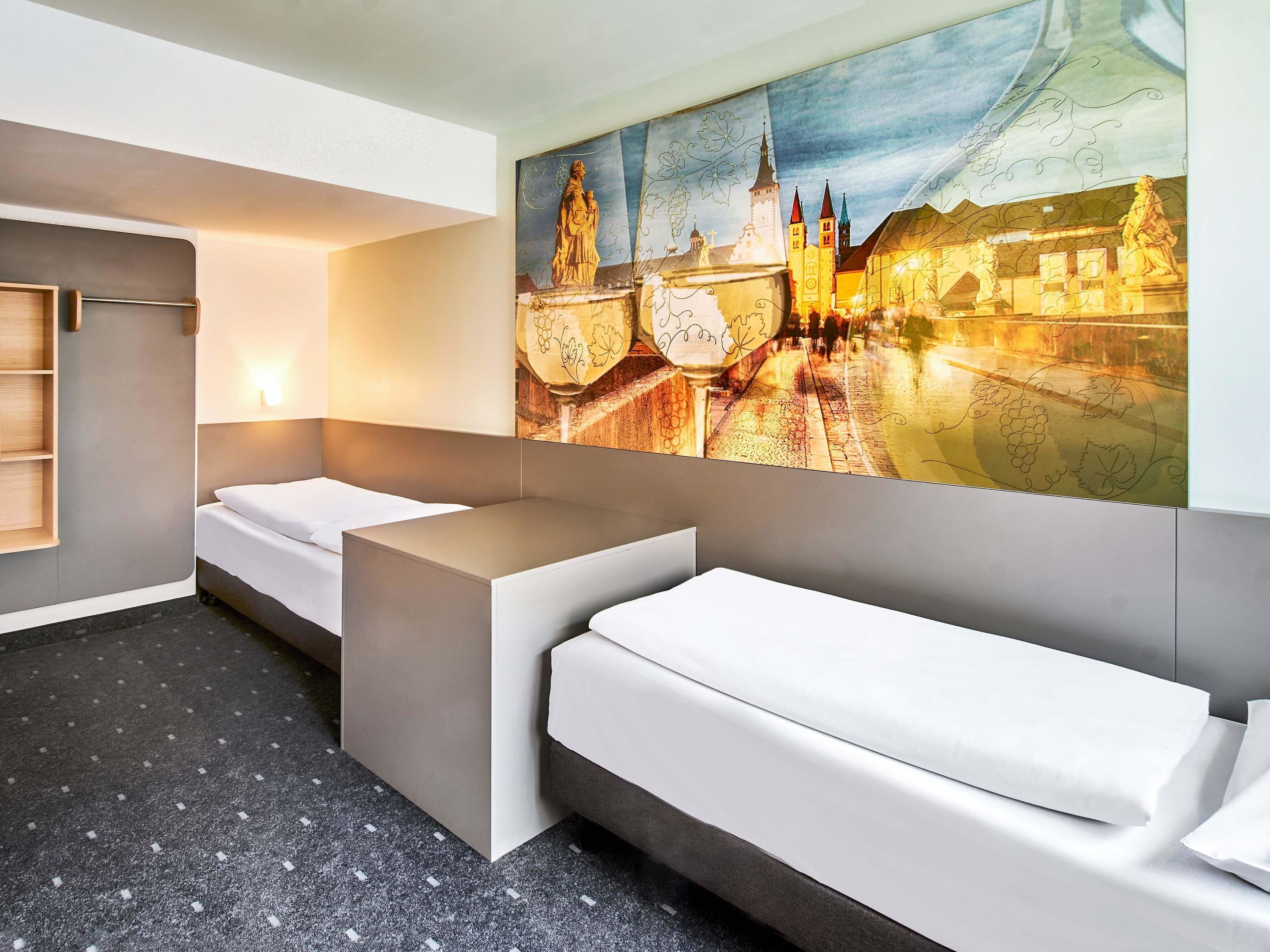 Ein modernes Hotelzimmer mit einem großen Bett, einer kleinen Sitzecke, einem Schreibtisch und einem an der Wand befestigten Fernseher.