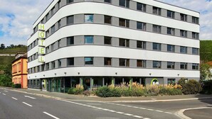 A modern hotel with a curved facade, multiple floors, and a prominent 'HOTEL' sign. - B&B HOTEL Würzburg-City (Würzburg)