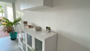Una stanza moderna con un armadietto bianco, una pianta in vaso e un cesto di vimini.