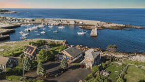 Un port de plaisance situé sur la côte, avec des bateaux, une jetée et des immeubles résidentiels.