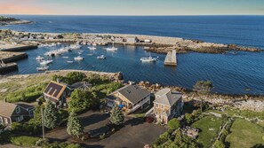 Un puerto costero con barcos, un muelle y edificios residenciales.