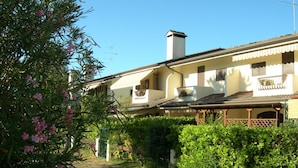 A traditional building with a tiled roof, a balcony with a railing, and a chimney.