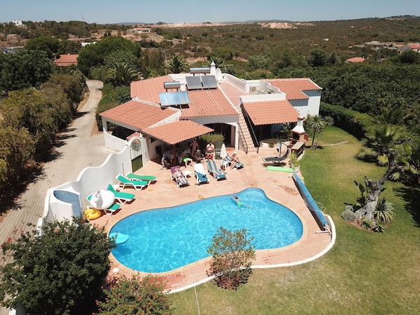 A large house with a swimming pool, a slide, and a patio area with sun loungers. - Family Getaway in the Algarve (Albufeira)
