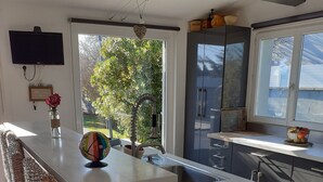 Eine moderne Küche mit großem Fenster, integriertem Spülbecken und Essbereich mit Bank.