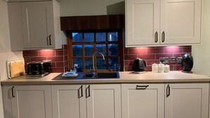 Una cocina con armarios blancos, un lavamanos doble y una ventana con vistas al exterior.