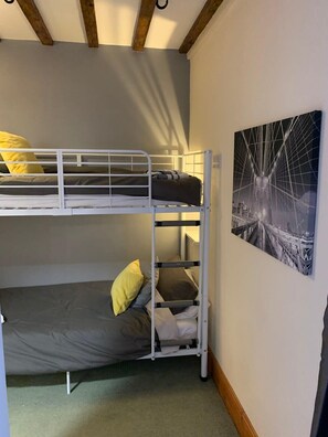 A bunk bed room with a cityscape painting on the wall. - Apartment One, The Carriage House. (York)