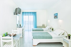 A modern hotel room with two beds, a desk with a laptop, a TV mounted on the wall, and a large window with blue curtains.