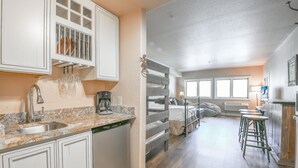 A kitchen with a granite countertop, white cabinets, and a built-in dishwasher. - Studio | Walk to Festivals & Summer Fun (Keystone)