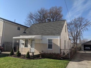 Cozy home with a covered porch, brick foundation, and attached garage.