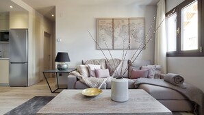 Un salon moderne avec un canapé, une table basse et une composition décorative faite de branches.