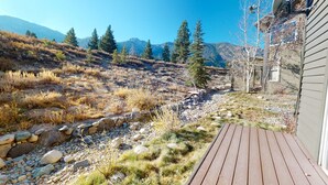 A wooden deck leading to a house with a mountainous backdrop. - Snowcreek V 774 Gorgeous Mountain Views with Private Garage, Washer Dryer and Gas Grill by RedAwning (Mammoth Lakes)