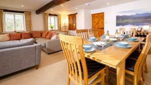 A dining area with a wooden table set for six, surrounded by wooden chairs. - Barn End - Three Bedroom House, Sleeps 6 (Skelwith)