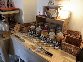 Exposição de alimentos com diversos potes rotulados com ingredientes como tâmaras, amêndoas e mel.