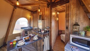 Cocina compacta con detalles de madera, un microondas y un comedor con mesa lista para el desayuno.