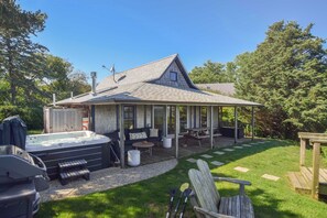 A house with a covered patio, a hot tub, and outdoor seating. - Seaside Retreat w/ Private Beach Landing! (Eastham)