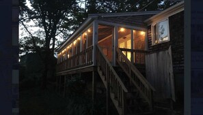 Een houten chalet met een overdekte veranda en een trap naar de ingang.