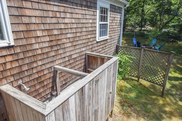 A wooden house with a small window and a wooden fence.