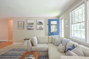 Una sala de estar con un sofá color beige, una mesita de centro y una puerta azul.