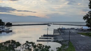 Näkymä järvelle, jossa on laituri, piknikpöytä ja veneitä.