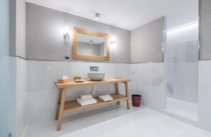Une salle de bain moderne avec un meuble-lavabo en bois, un grand miroir et une cabine de douche en verre.