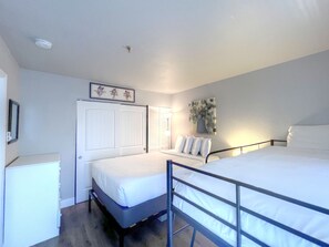 A bedroom with two beds, a white wardrobe, a framed picture, and a wall-mounted lamp. - LOCATION! Base Area Trails Right Outside your Door! GREAT RATES! (Mt. Crested Butte)