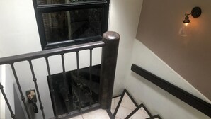 A staircase with a black metal railing, a glass door, and a wall-mounted light fixture. - Woodlands San Rafael Heredia , Costa Rica (Montecito)