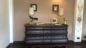 A dark wooden dresser with multiple drawers, two wall-mounted lamps, and framed pictures. - Woodlands San Rafael Heredia , Costa Rica (Montecito)