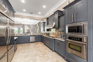 Enjoy cooking in this well-equipped kitchen with a refrigerator, dishwasher, microwave, and oven, plus ample workspace and a range hood.